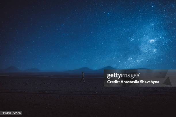 vrouw wandelingen onder de miljoen sterren en melkweg in atacama desert - dark space stockfoto's en -beelden