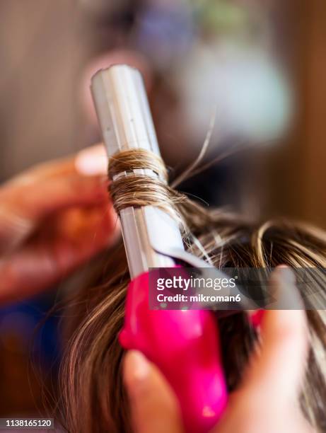 hairdresser curling womens hair at a salon - curling imagens e fotografias de stock