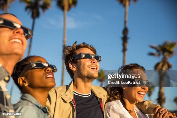 los angelinos sur le boulevard venice beach et plage s'amuser dans une journée ensoleillée en californie - éclipse solaire photos et images de collection