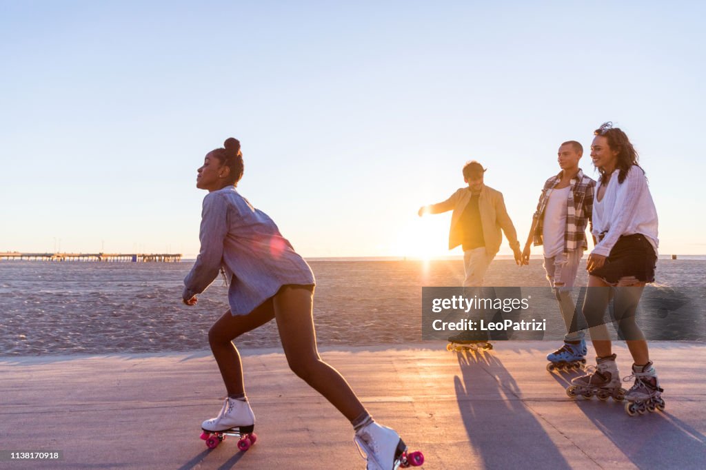 Friends roller skating on the boardwalk in Venice Beach - Santa Monica promenade - Los Angeles, USA
