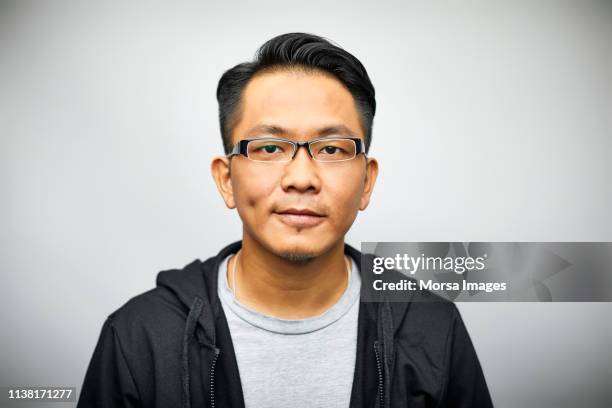 confident young man smiling on white background - man expressive background glasses stock-fotos und bilder