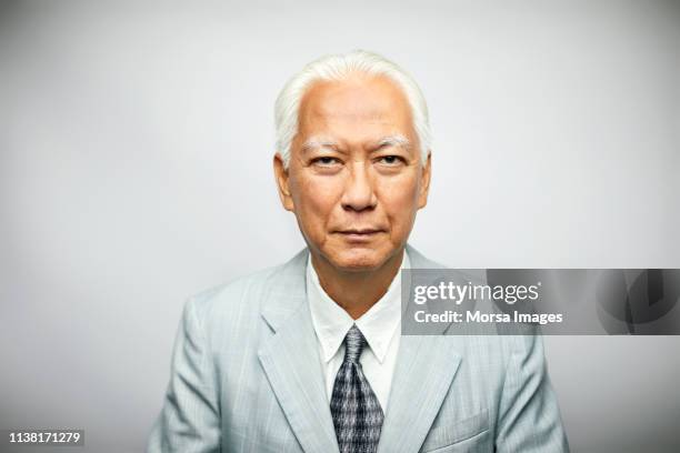 portrait of senior businessman wearing suit - elderly chinese man stock-fotos und bilder