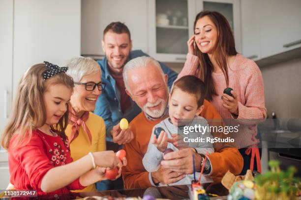 familia de múltiples generaciones con huevos de pascua y sonriendo - pascua fotografías e imágenes de stock