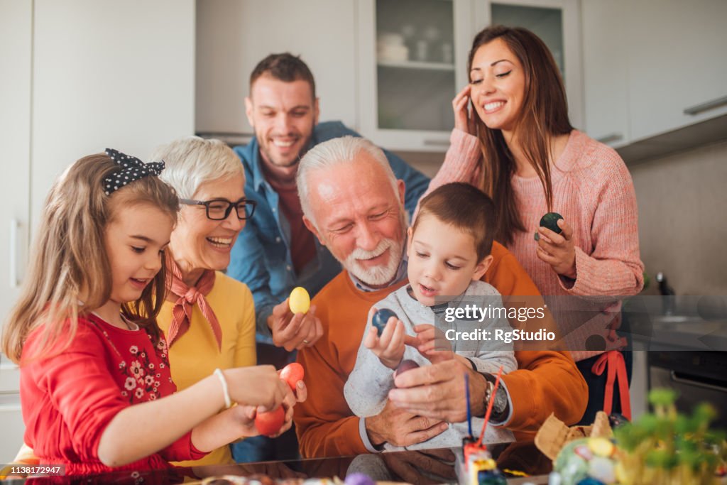 Multi-generation family holding Easter eggs and smiling