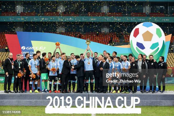 Players of Uruguay attend the award ceremony and Diego Godin rises up the trophy after 2019 China Cup International Football Championship between...