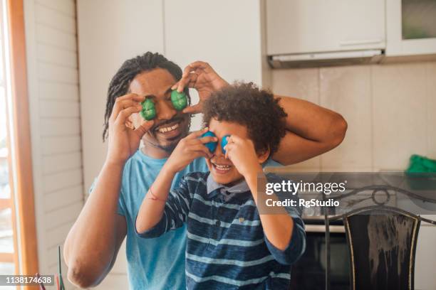 vater und sohn, die dun ostereier schmücken - african family easter stock-fotos und bilder