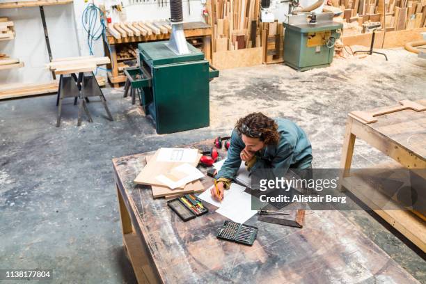 designer working at a bench in a furniture factory - designer einrichtung stock-fotos und bilder