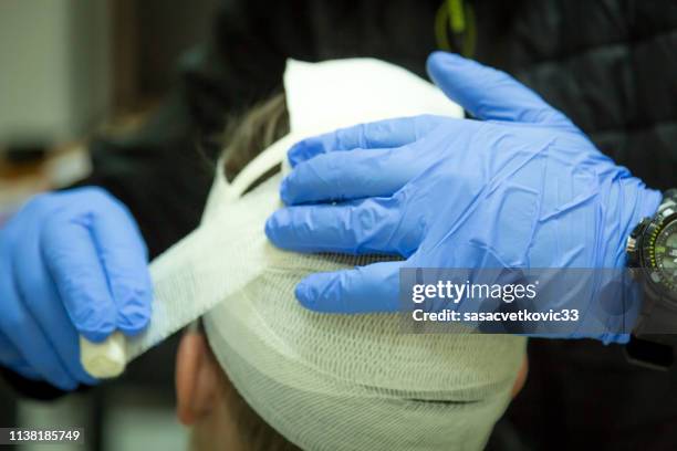 treinamento de primeiros socorros, atadura principal - head injury - fotografias e filmes do acervo