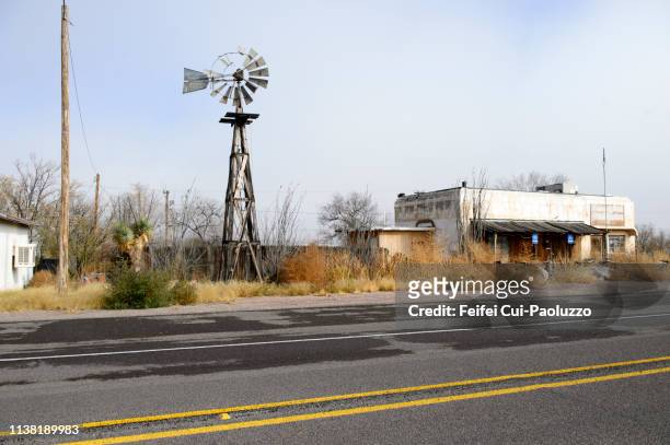 abandoned building and traditional windmill at sierra blanca, texas, usa - americana blanca imagens e fotografias de stock
