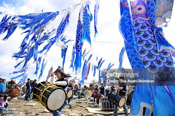 High school students play Japanese drums under the blue carp streamers to commemorate earthquake and tsunami victims at the place where one of the...