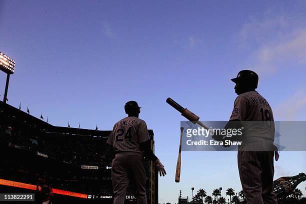 Dexter Fowler and Jonathan Herrera of the Colorado Rockies warm up before the start of the first inning of their game against the San Francisco...