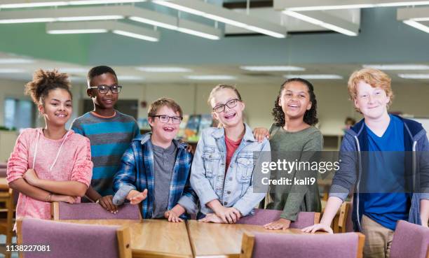 boy with down syndrome, classmates in school library - children only stock pictures, royalty-free photos & images