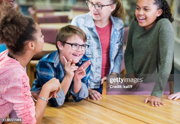 boy with down syndrome, classmates in school library - children only stock pictures, royalty-free photos & images