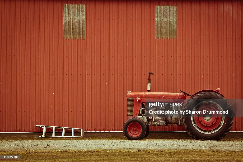 Tractor and Ladder beside Barn