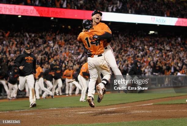 Cody Ross and Mike Fontenot of the San Francisco Giants celebrate after Ross scored the winning run on a hit by Freddy Sanchez in the bottom of the...