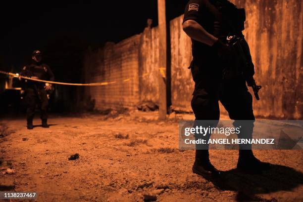 Members of the Minatitlan municipal police stand guard outside the place where 13 people were killed in a shooting, in Minatitlan, Veracruz State,...