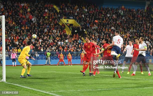 Michael Keane of England scores his team's first goal past Danijel Petkovic of Montenegro during the 2020 UEFA European Championships Group A...