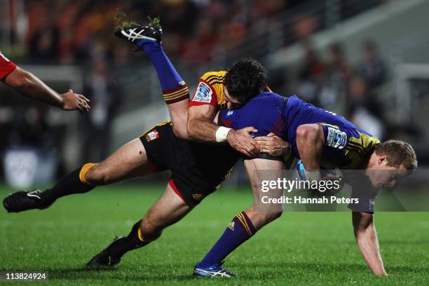 Stephen Donald of the Chiefs tackles Kendrick Lynn of the Highlanders during the round 12 Super Rugby match between the Chiefs and the Highlanders at...