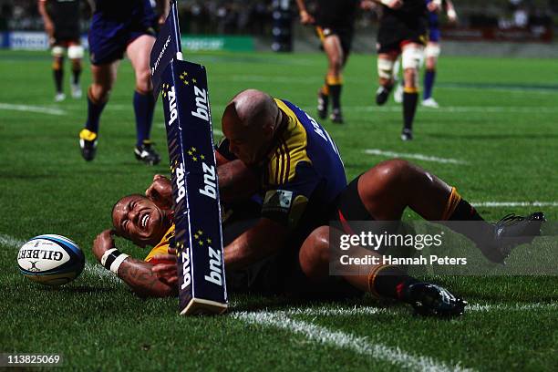 Jason Rutledge of the Highlanders tackles Hika Elliot on the tryline during the round 12 Super Rugby match between the Chiefs and the Highlanders at...