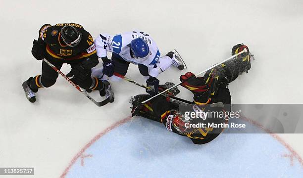 Dennis Endras of Germany makes a save on Janne Naskala of Finland during the IIHF World Championship qualification match between Germany and Finland...