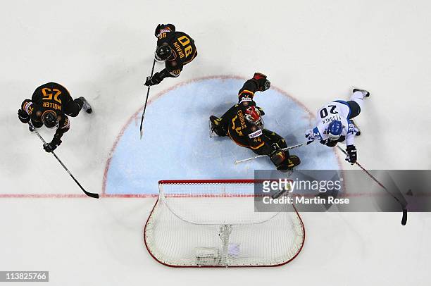 Dennis Endras of Germany makes a save on Janne Pesonen of Finland during the IIHF World Championship qualification match between Germany and Finland...