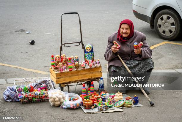 An elderly woman sells Easter eggs and Russian souvenirs on a street in central Moscow on April 20, 2019. - Orthodox Christians celebrate Easter on...