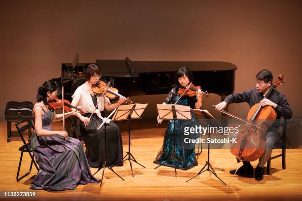 vier musiker, die violine und cello beim konzert mit klassischer musik spielen - kleine personengruppe stock-fotos und bilder