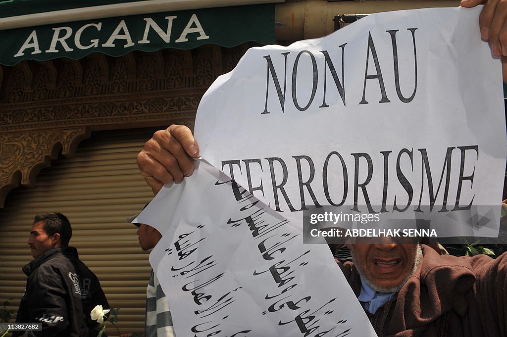 A man holds a bannerr reading "No To Ter