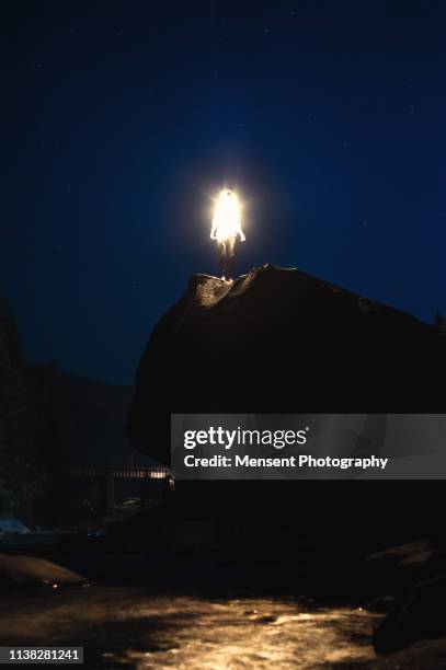 man glows with neon light against night sky in mountains - rocky star stock pictures, royalty-free photos & images