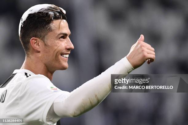 Juventus' Portuguese forward Cristiano Ronaldo, his hair covered in foam, acknowledges fans and celebrates after Juventus secured its 8th consecutive...
