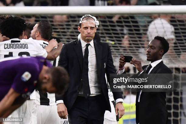 Juventus' Italian coach Massimiliano Allegri , his head covered in foam, reacts as Juventus players celebrate after securing the club's 8th...