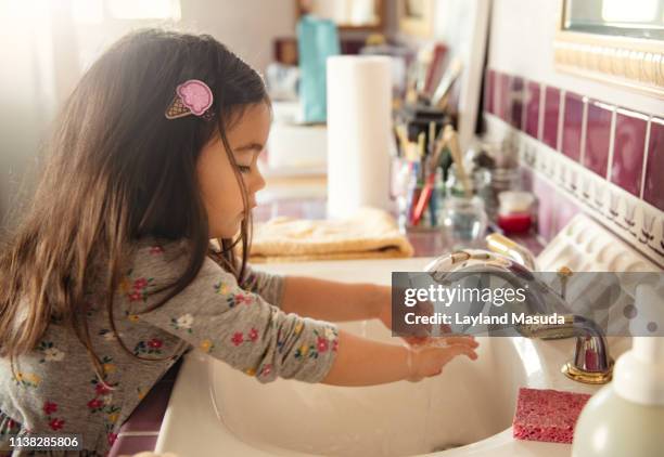 toddler girl washing her hands after painting - child washing hands stockfoto's en -beelden