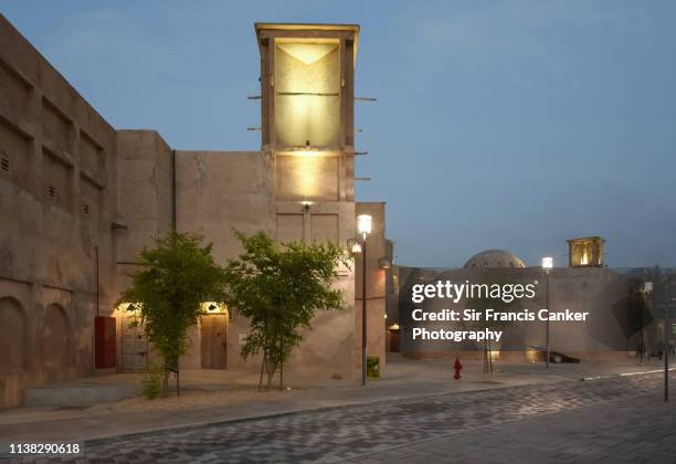 badgir (wind tower) illuminated at dusk in al bastakiya district of dubai, uae - old town stock pictures, royalty-free photos & images