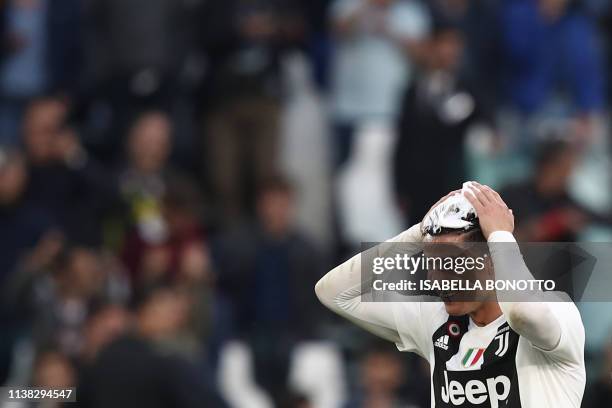 Juventus' Portuguese forward Cristiano Ronaldo, his hair covered in foam, celebrates after Juventus secured its 8th consecutive Italian 2018/19...