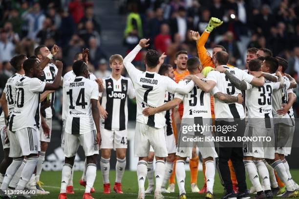 Juventus' Portuguese forward Cristiano Ronaldo and Juventus players celebrate after Juventus secured its 8th consecutive Italian 2018/19 "Scudetto"...