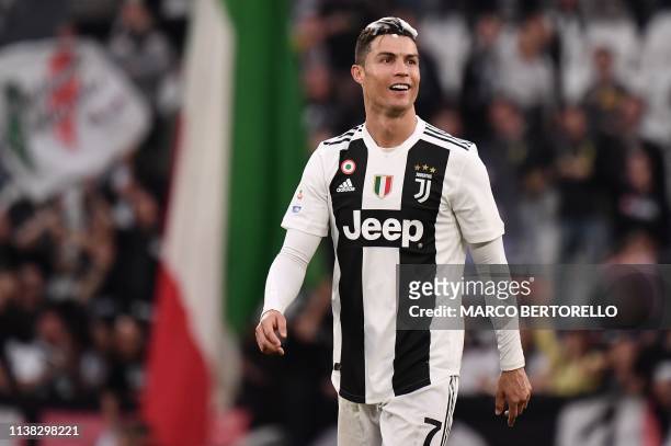 Juventus' Portuguese forward Cristiano Ronaldo, his head covered in foam, acknowledges fans and celebrates after Juventus secured its 8th consecutive...
