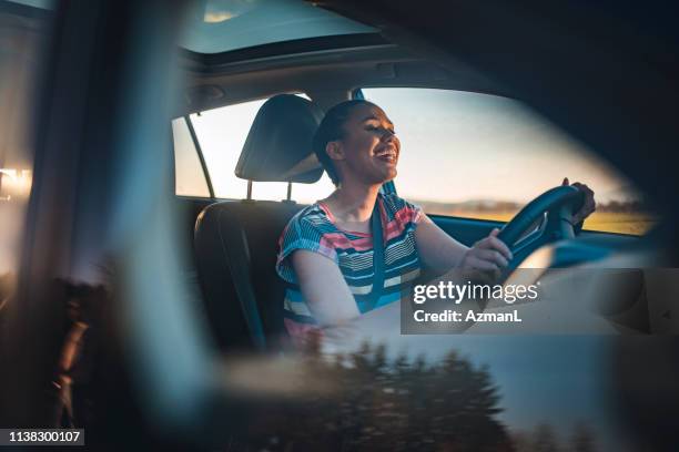 junge frau fährt auto an einem sonnigen tag - auto singen stock-fotos und bilder