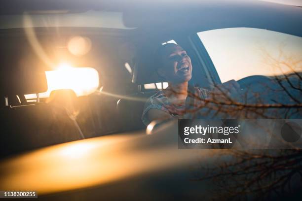 junge frau fährt auto an einem sonnigen tag - auto singen stock-fotos und bilder