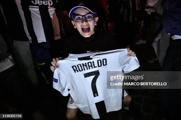 Young supporter holds a Ronaldo jersey as Juventus fans celebrate in downtown Turin after Juventus secured its 8th consecutive Italian 2018/19...