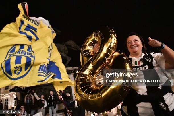 Woman holds an inflatable number 8 as Juventus fans celebrate in downtown Turin after Juventus secured its 8th consecutive Italian 2018/19 "Scudetto"...