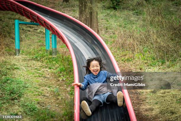 little girl playing on park - deslizar - fotografias e filmes do acervo