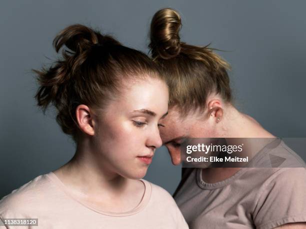 teenagers with their heads together - feeling guilty stock-fotos und bilder