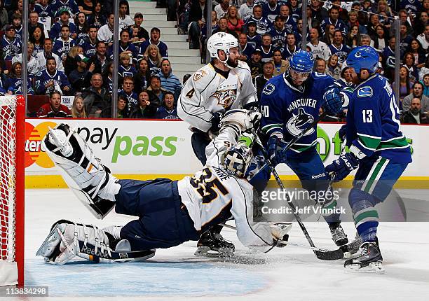 Goaltender Pekka Rinne of the Nashville Predators makes a save in front of teammate Cody Franson while Raffi Torres Maxim Lapierre of the Vancouver...