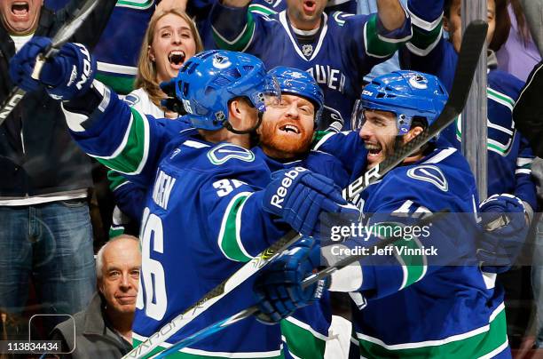 Maxim Lapierre and Jannik Hansen of the Vancouver Canucks celebrate goal by Raffi Torres against the Nashville Predators during Game Five of the...