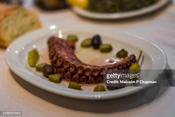 cooked octopus tentacle served with olives, spinach, and bread, eresos, lesvos, greece - lesvos stock pictures, royalty-free photos & images