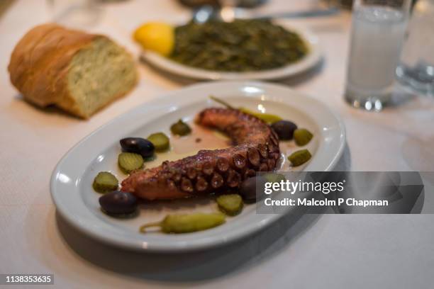cooked octopus tentacle served with olives, spinach, ouzo and bread, eresos, lesvos, greece - ouzo stock pictures, royalty-free photos & images