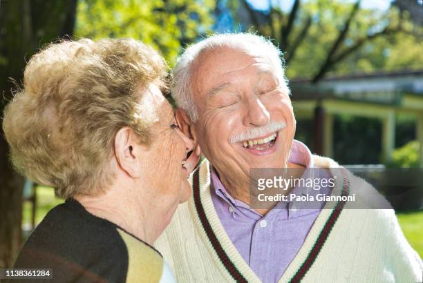 konzept der pensionierten gemeinden. ältere großeltern lächeln glücklich im garten - gerontology stock-fotos und bilder