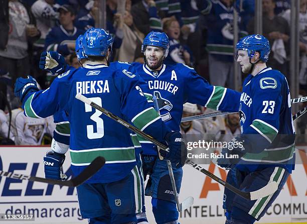 Ryan Kesler of the Vancouver Canucks celebrates with Kevin Bieksa and Alexander Edler of the Vancouver Canucks after scoring against the Nashville...