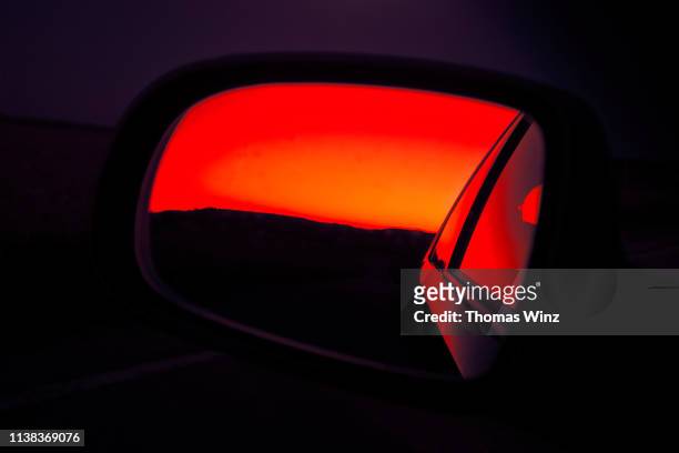 sunset in rearview mirror - atmosferische lucht stockfoto's en -beelden