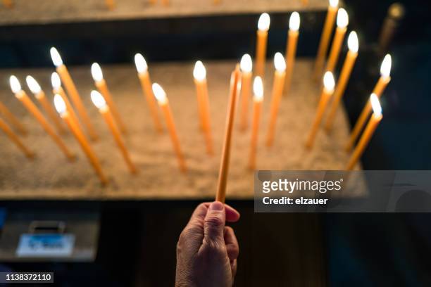 burning candle in bamberg cathedral - lighting candle stock pictures, royalty-free photos & images